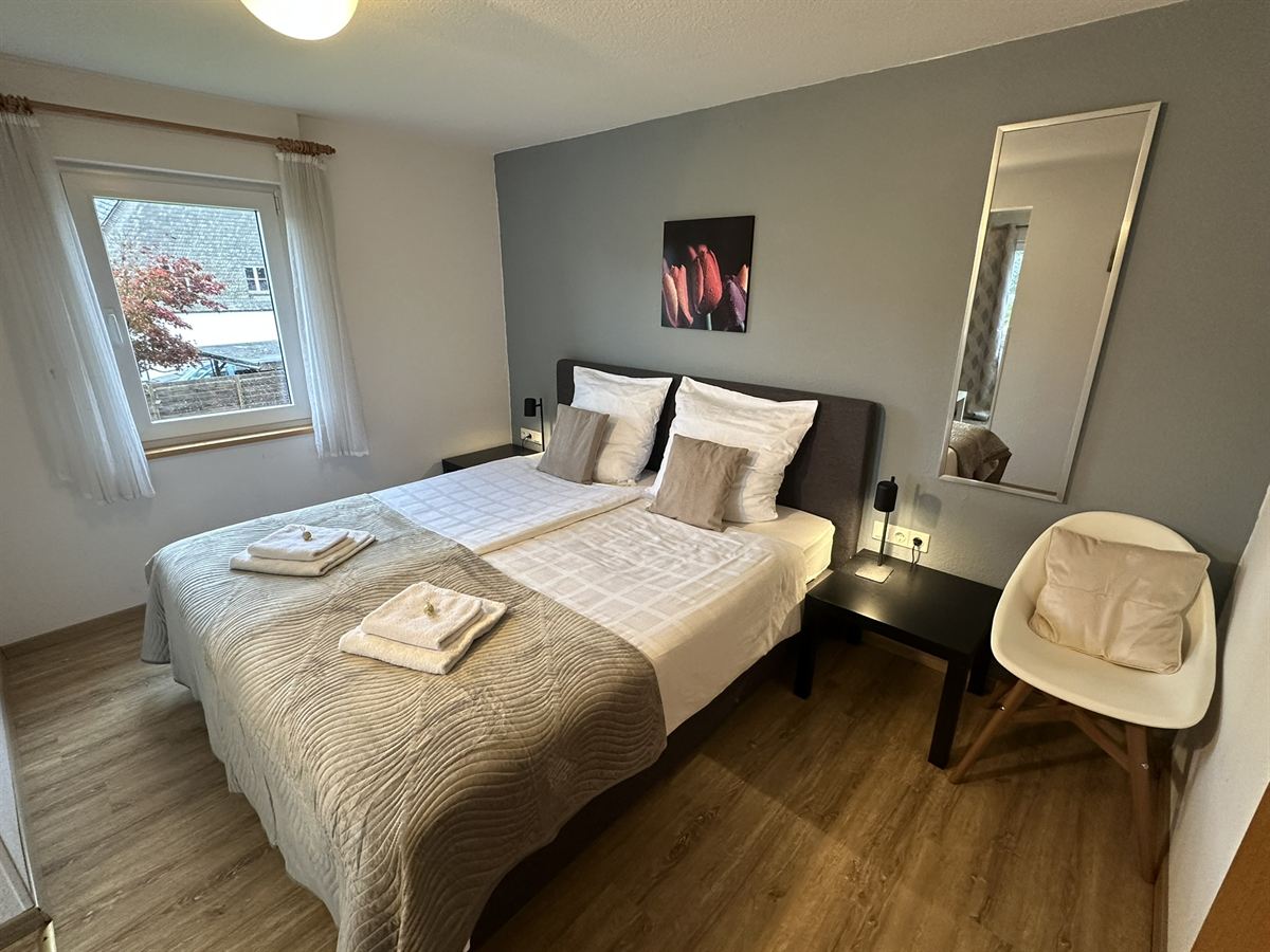 Bright room with box-spring bed at the Haus Astenalm guesthouse